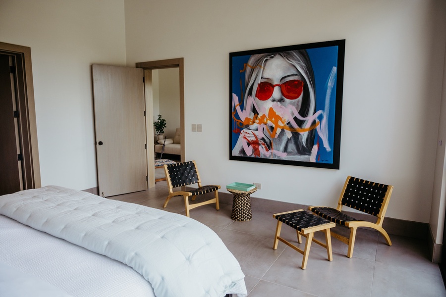 Slumber in the guest bedroom with a large bed and a unique art piece on the wall.