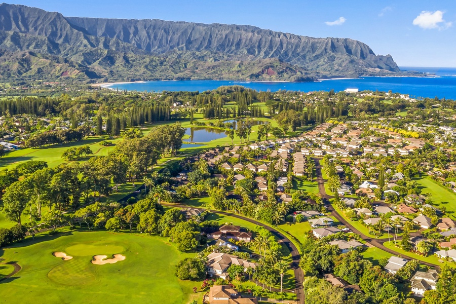 A stunning aerial view of Princeville with mountains and ocean in the background.