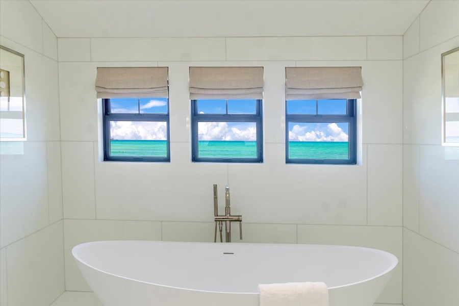 Soak in luxury with an oversized tub and framed tropical views.