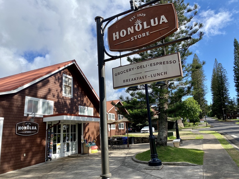 Charming roadside store with sign advertising grocery, deli, espresso, breakfast, and lunch options.