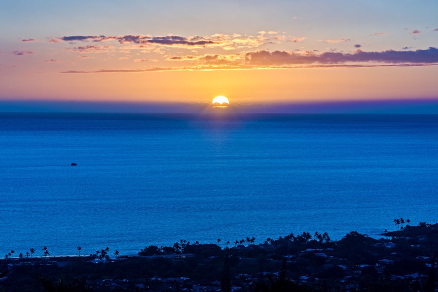 Breathtaking ocean sunset creates a spectacular backdrop, painting the sky in brilliant oranges and purples over the endless blue waters.