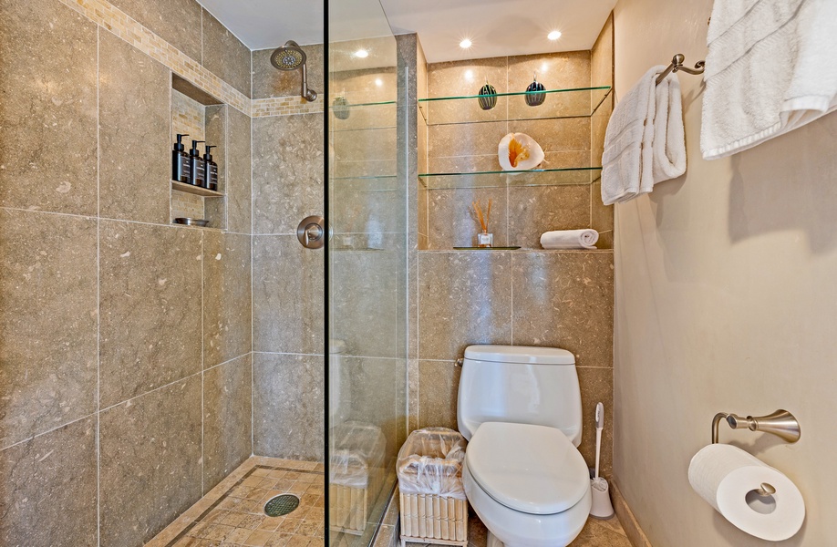 The bathroom at Royal Kahana 610 features a spacious walk-in shower with elegant tile and built-in shelving for a clean and modern look.