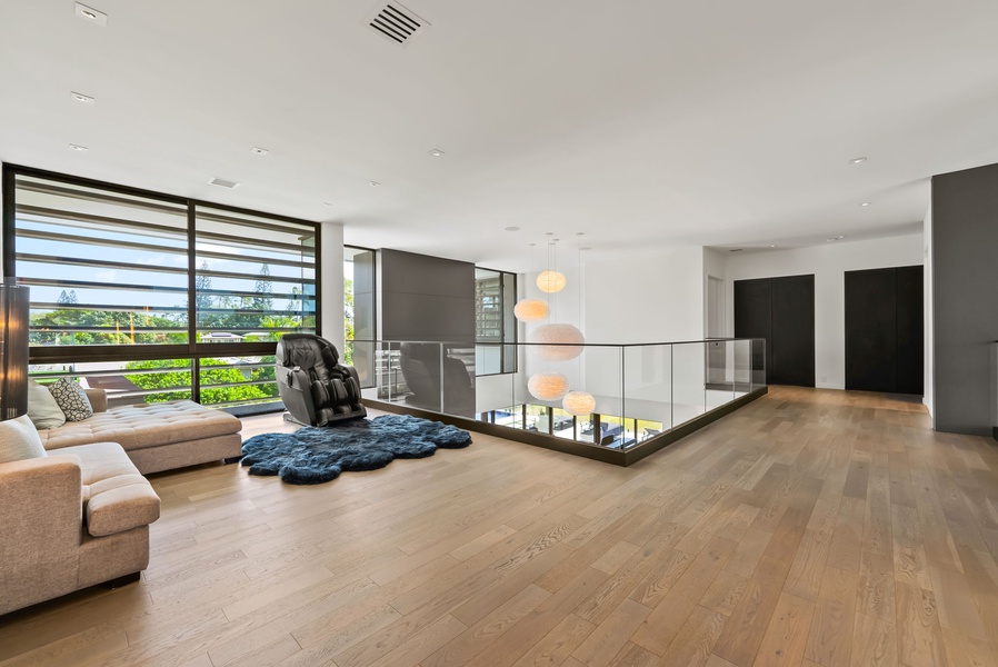 Spacious upper lounge with a futon, warm wood floors, and open flow.