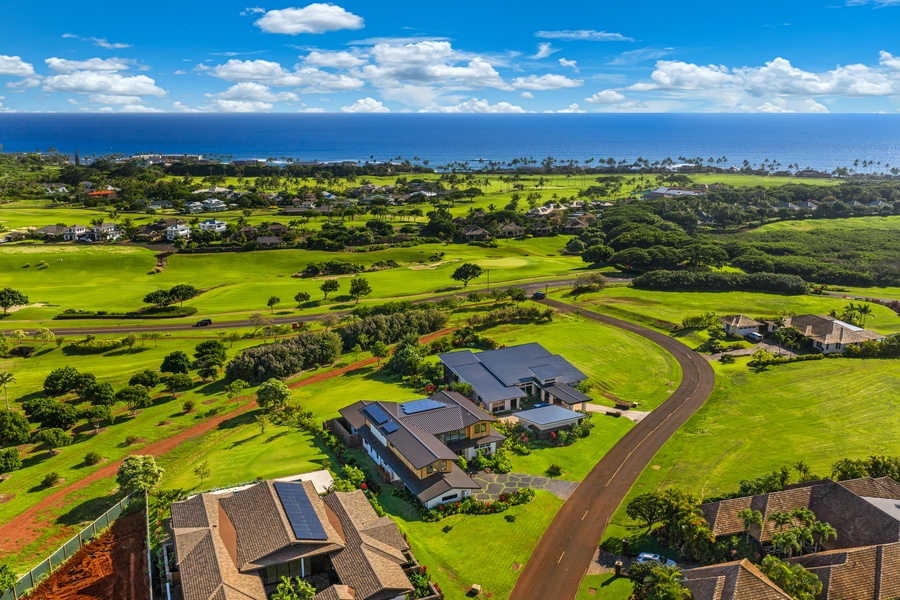 Aerial view showcases the property's prime location amid lush golf courses with stunning ocean backdrop and tropical landscape.
