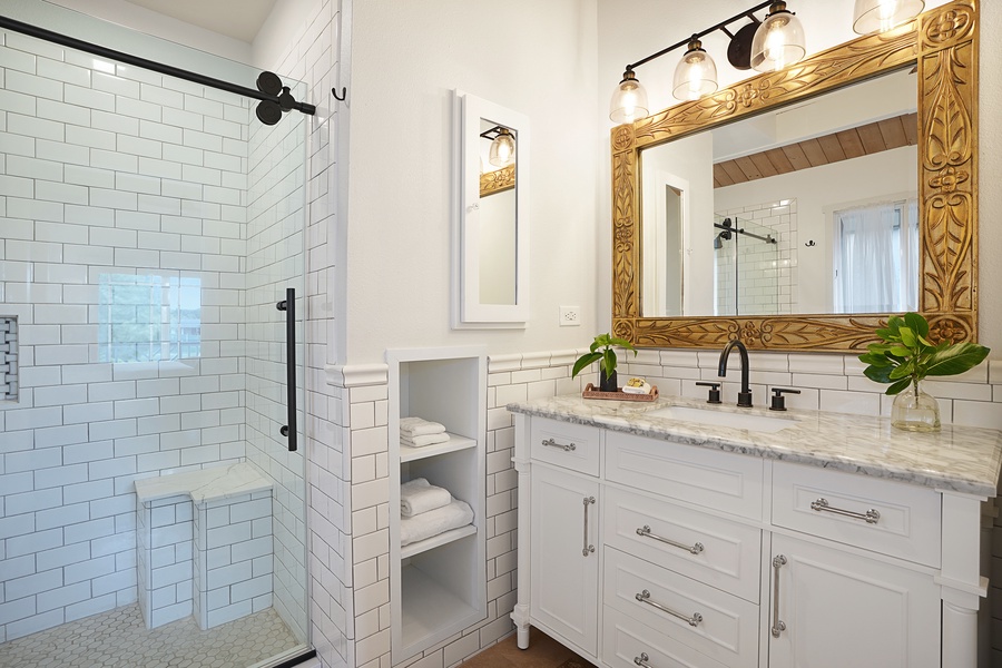 Primary Bathroom offers a tiled walk-in shower and marble sink