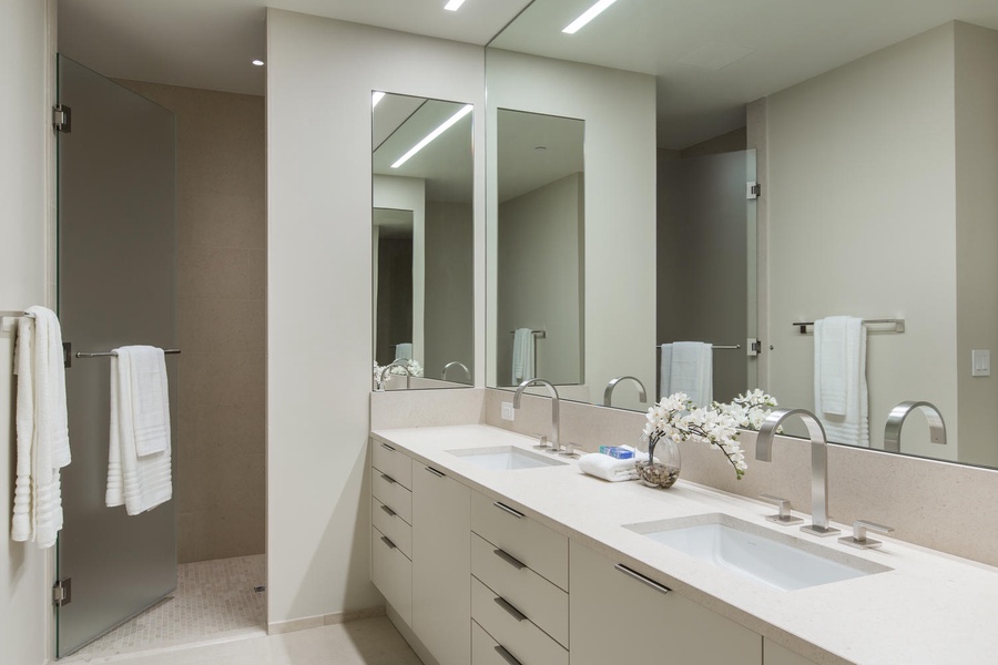Your elegant ensuite features dual vanities and a spacious glass-enclosed shower for luxurious morning routines.