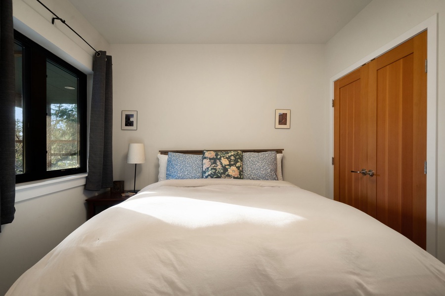 Your peaceful bedroom features a plush bed with soft linens, natural light streaming through large windows, and thoughtful touches creating the perfect retreat.