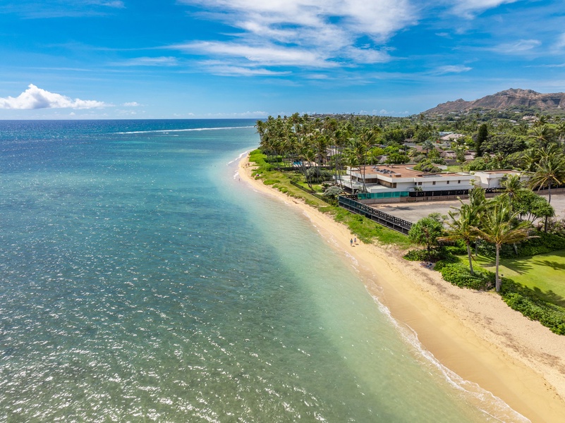 Stunning aerial view of a pristine beach and clear blue waters, perfect for relaxing by the ocean.