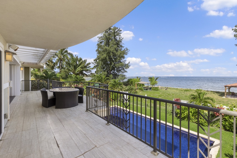 Second-floor entertaining deck with a view of the pool and ocean.