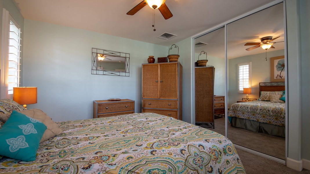 The second guest bedroom features a dresser and large mirror.