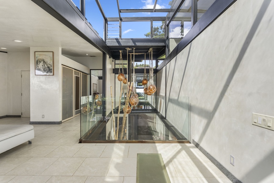 A striking glass atrium in the third level with modern decor, seamlessly blending indoor and outdoor elements.