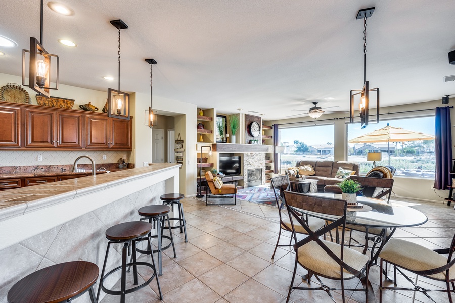 Where morning coffee meets evening chill: our kitchen bar and breakfast nook flows effortlessly into the living space, framing breathtaking backyard vistas.