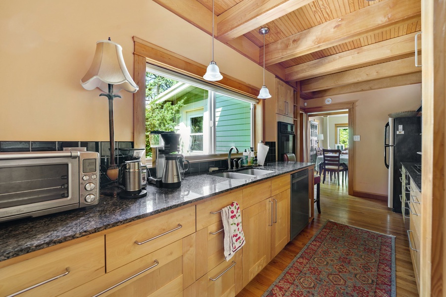 Your fully equipped kitchen features warm wood cabinetry and granite counters, perfect for cooking meals during your stay.