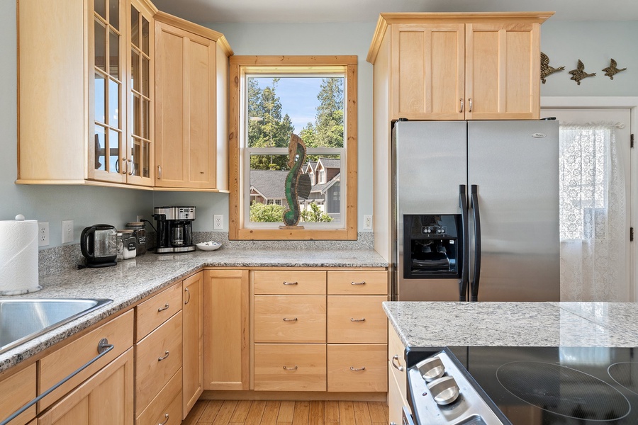 Ample storage and natural light flood this stunning kitchen with the help of sleek glass windows