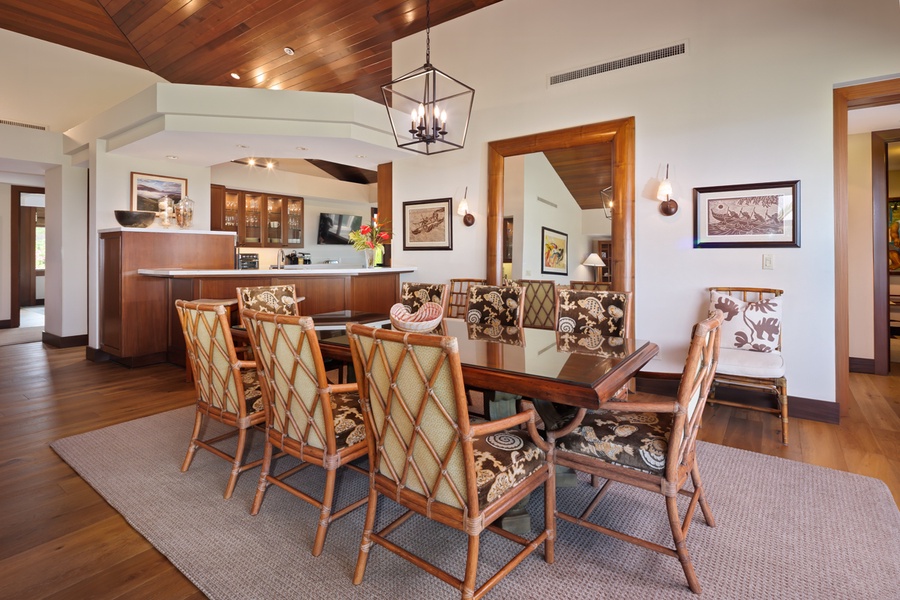 Gather around your elegant dining table under warm wood ceilings, where memorable meals unfold in sophisticated comfort.