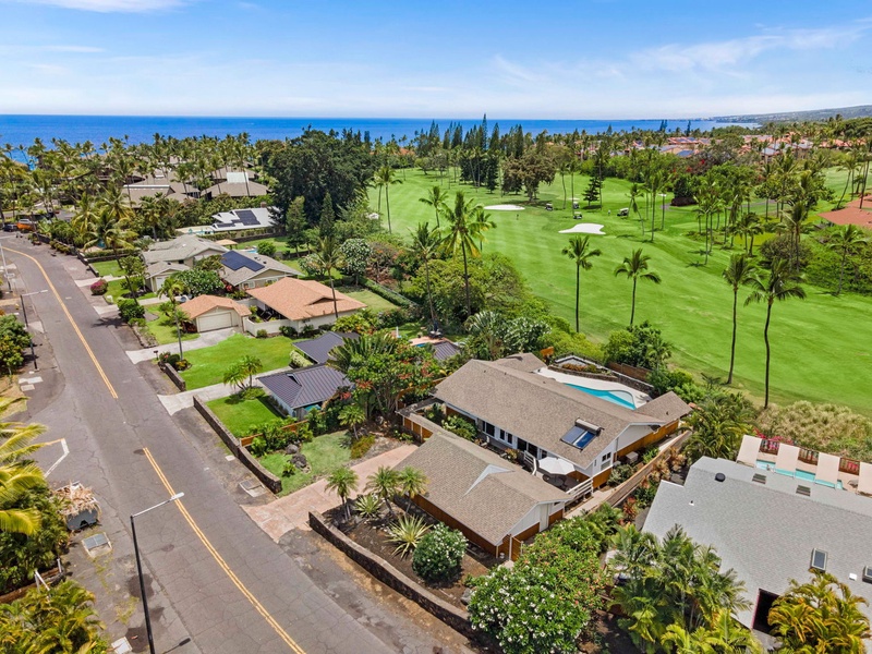 The neighborhood rolls down toward the water past the golf fairways.