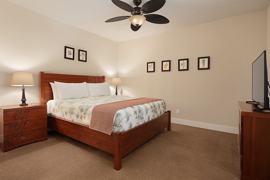 Sink into your plush king bed with tropical-themed linens while the ceiling fan creates a gentle breeze for perfect nighttime comfort.