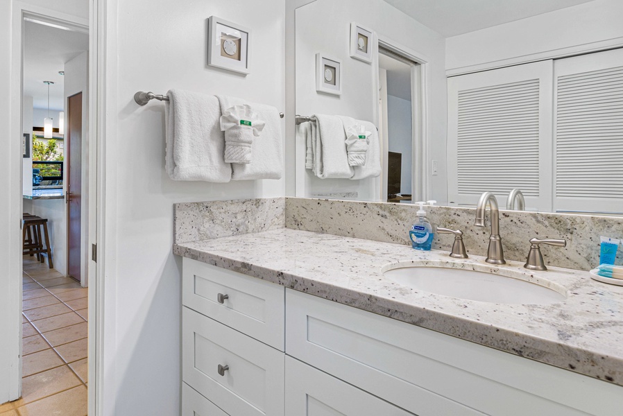 The bathroom features a spacious vanity with clean white finishes and plenty of counter space.