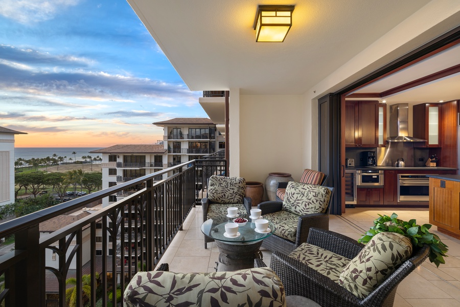 Cozy lanai setup with a view, adjacent to a sleek open kitchen.