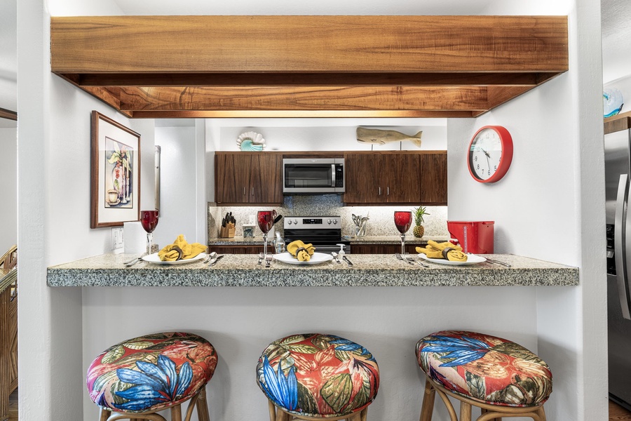Gather around your open kitchen island for breakfast with tropical-print bar stools and granite countertops creating the perfect casual dining spot.