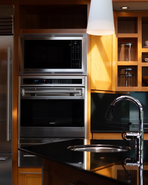 Prepare gourmet meals in your fully equipped kitchen featuring professional Wolf appliances, gleaming granite countertops, and warm wood cabinetry.