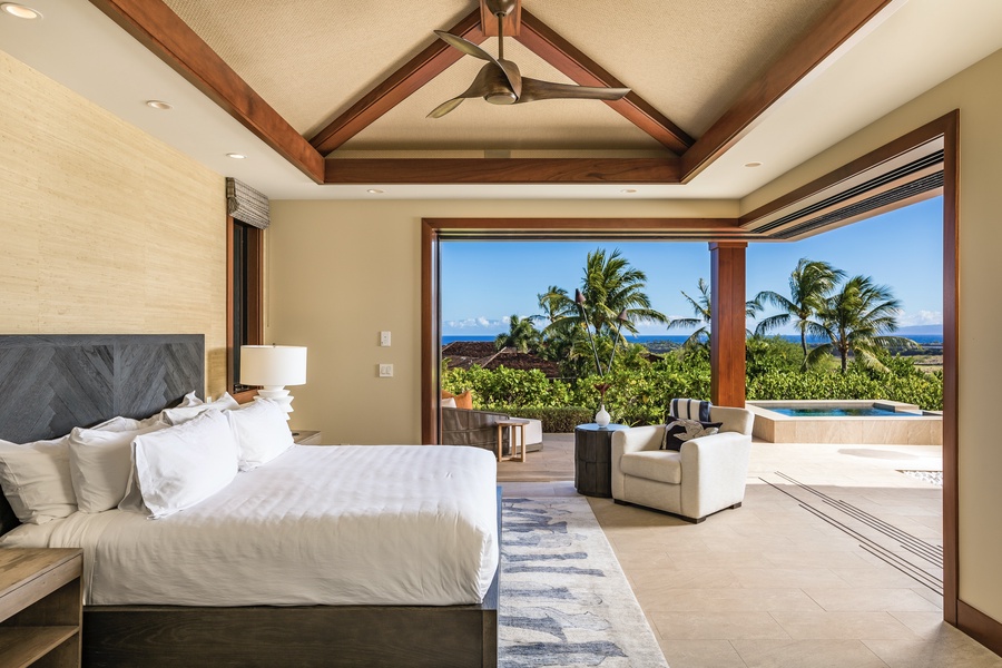 Primary suite expands onto the lanai via two walls of pocket doors, showcasing ocean, pool deck and mountain vistas.
