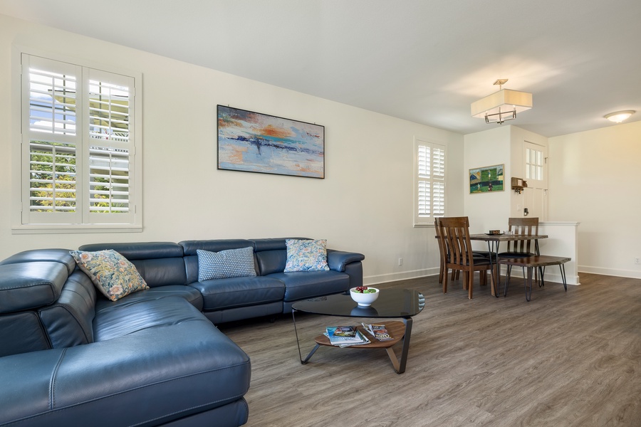 Unwind in your spacious living room with plush leather seating and warm natural light streaming through plantation shutters.