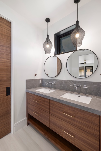 Elegant dual vanities and designer touches create a rejuvenating spa atmosphere for guests to enjoy.