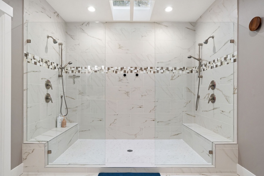 Step into your luxurious marble spa shower with dual rainfall heads and built-in seating for the ultimate relaxation.