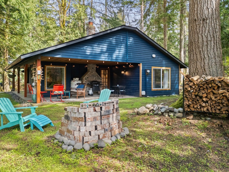 Freshly stacked firewood and charming cabin vibes greet guests upon arrival to this forested retreat.