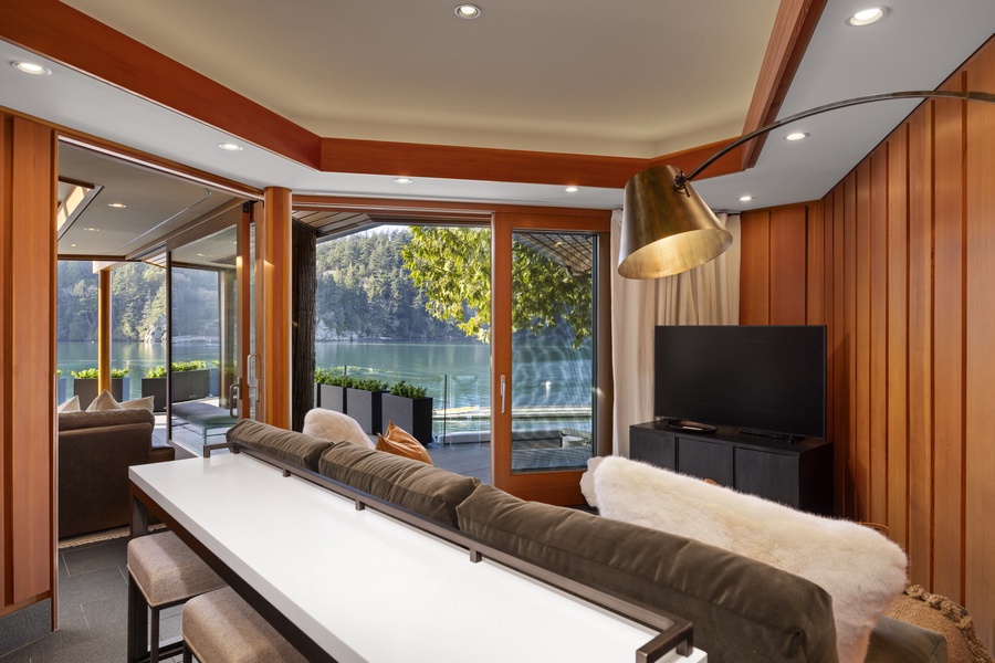 Sink into plush comfort while gazing at pristine lake views through floor-to-ceiling windows in your modern lakefront retreat.