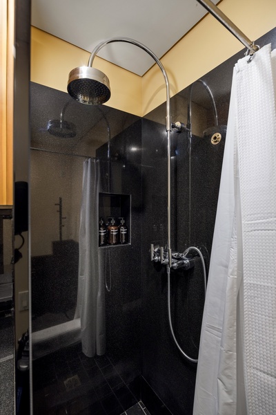 Step into your sleek private shower featuring modern fixtures and glass doors for a refreshing start to your day.