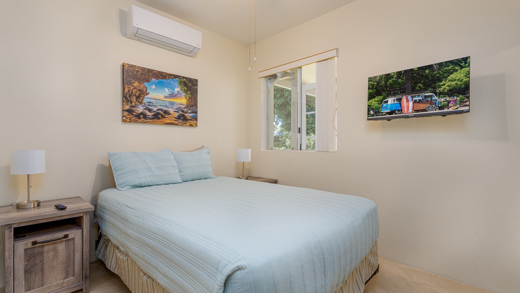 The second guest bedroom is well appointed with soft linens and tropical art.
