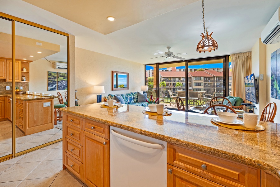 The spacious kitchen island provides extra counter space for meal prep, with a view of the living area and lanai.