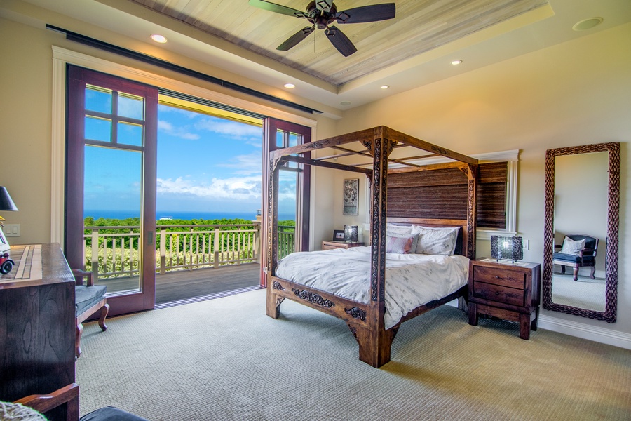 Guest Bedroom with Canopied Bed and Doors that Open to Bring in the Outside and View of the Ocean with En Suite Bathroom