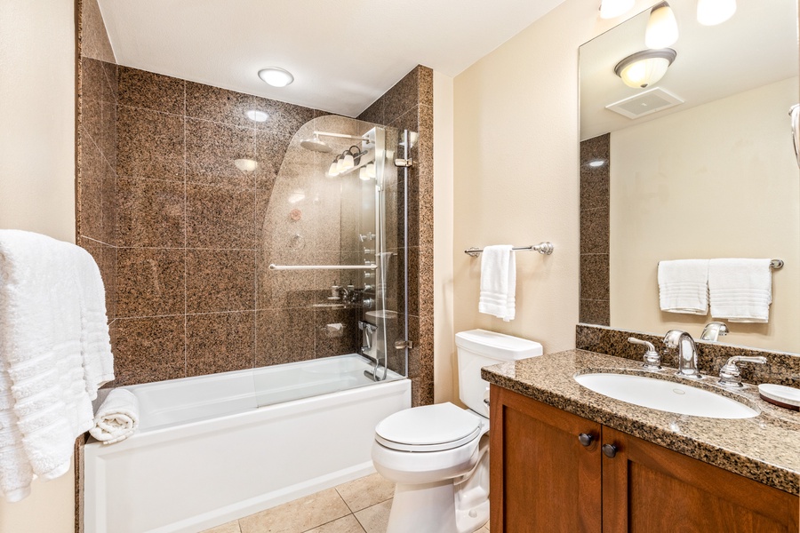 Full bathroom adjacent to guest bedroom with soaking tub/shower combo.