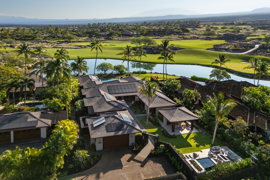 Stunning aerial view showcases the tropical property nestled within championship golf greens.