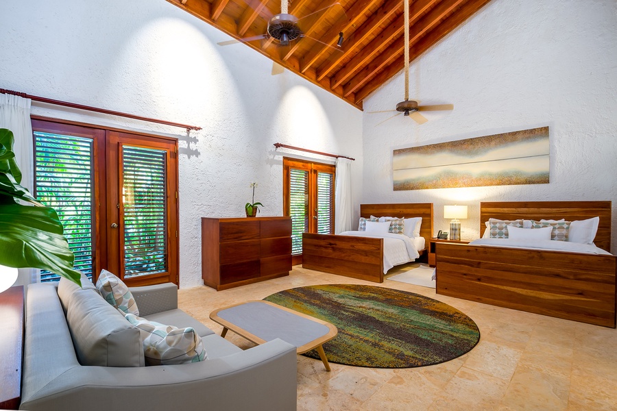 Inviting guest bedroom with two beds and a cozy sitting area.