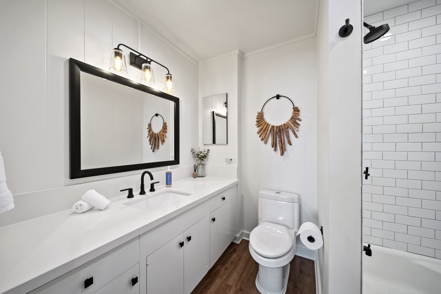 Guest bathroom with a sleek double vanity, large mirror, and coastal-inspired décor — perfect for easy mornings.