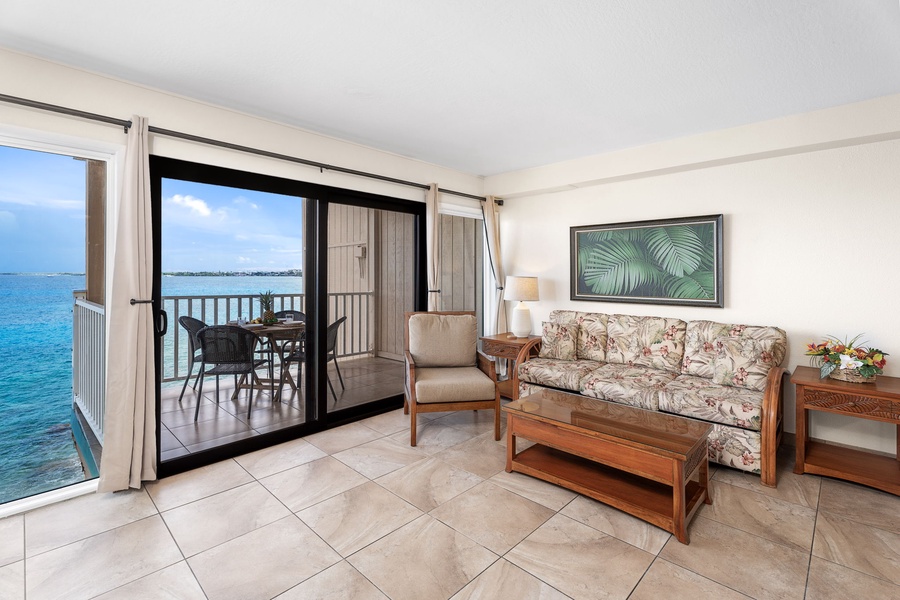 Relax after a day in Kona in the cozy living area with plush sofa sleeper, ceiling fan, and flat-screen TV.