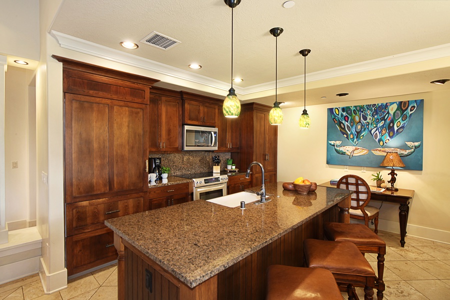 Kitchen with bar seating, ample appliances and spaces for your culinary delights.