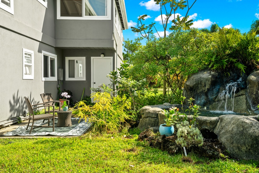 A quiet garden spot surrounded by green plants and flowers.