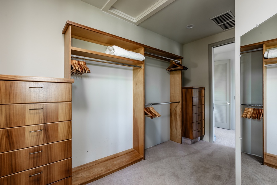 Spacious walk-in closet with built-in shelving and ample storage space.