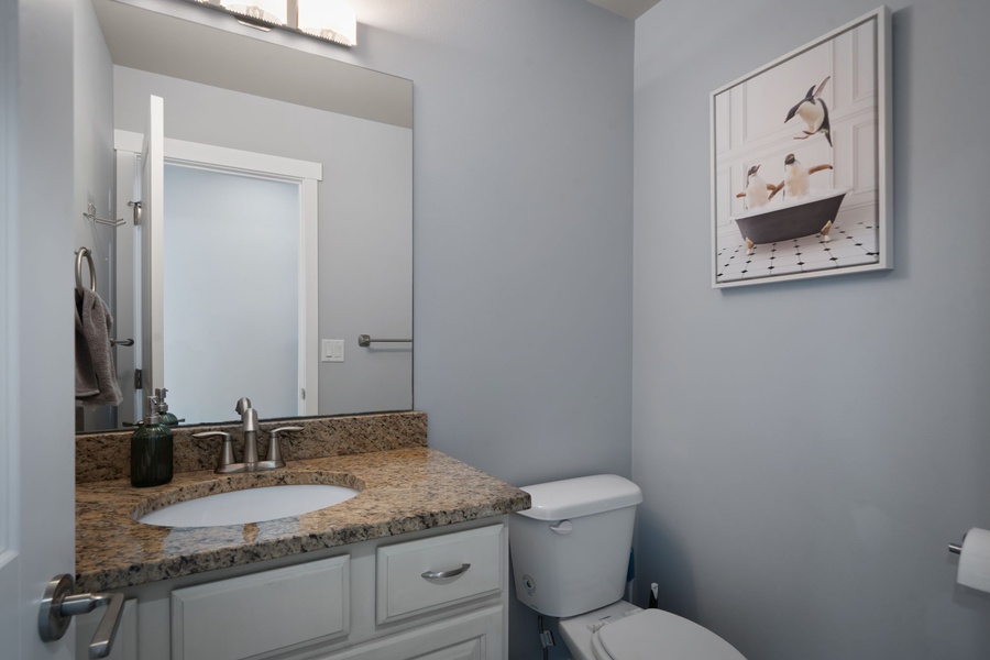 The convenient half bathroom offers modern finishes and easy access for guests throughout the home.