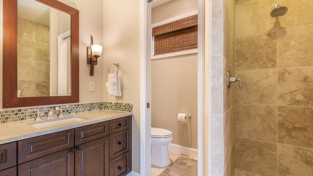 Fourth bath, with sandstone tiles and ocean-toned backsplash.