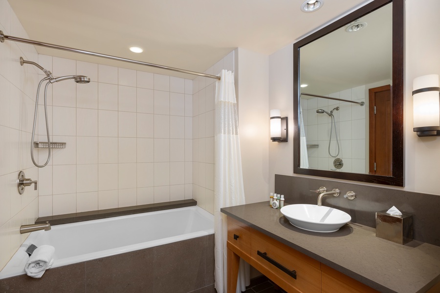 The second guest bathroom features a shower and tub combo, perfect for a refreshing rinse after a day at the beach.