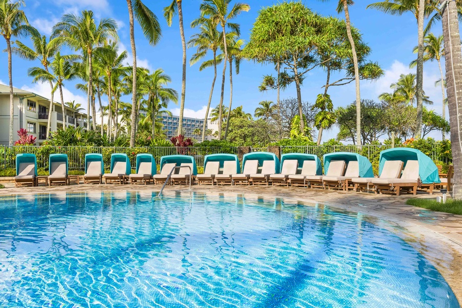Tropical paradise awaits with crystal-clear pool waters, comfortable loungers, and swaying palms creating your perfect Hawaiian escape.