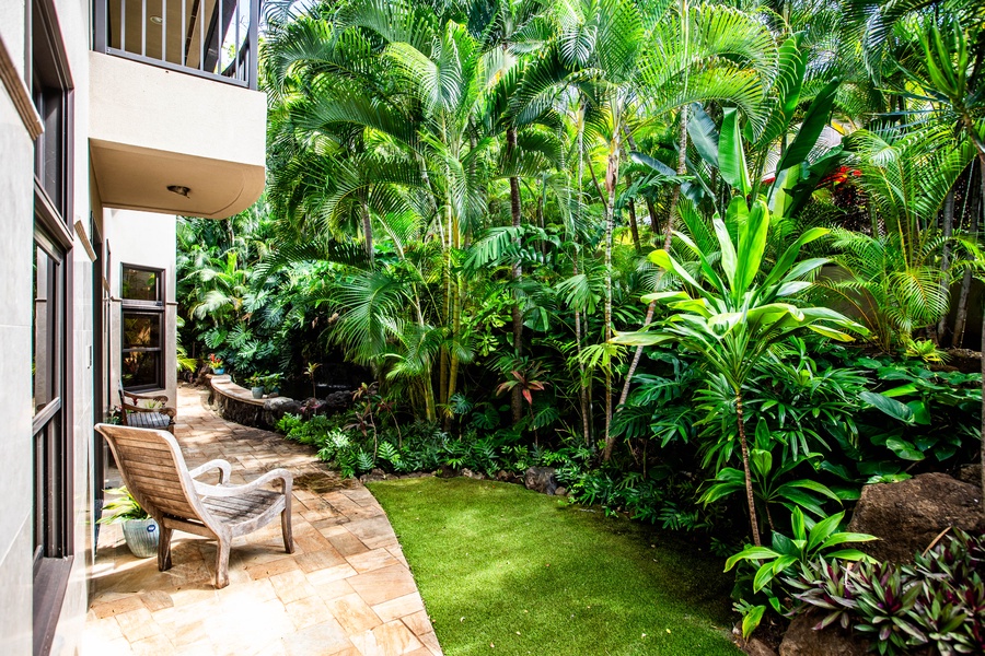 Private backyard garden space with stone path and lawn.