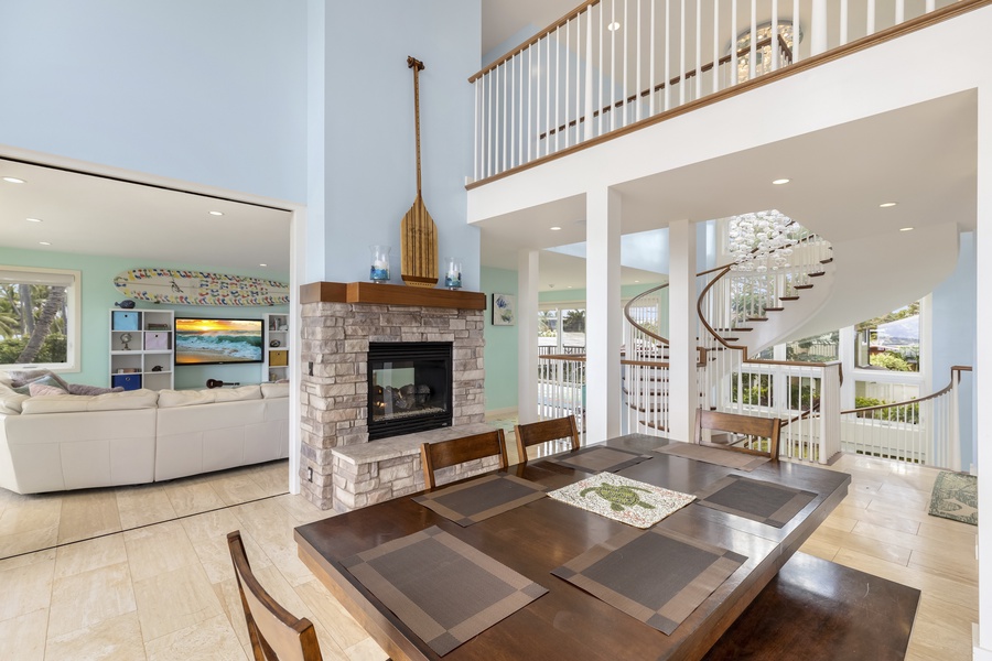 A dining space with a gas fireplace and a wall of custom pocket doors flows out to an open-air dining area, or into a comfortable living space with plenty of seating and a sizable television