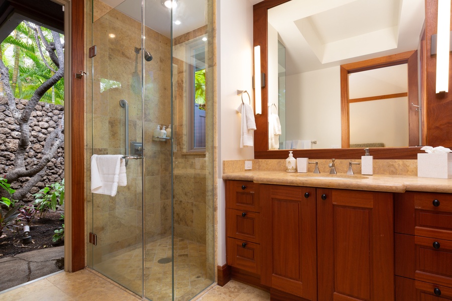 The en suite bath features a walk-in shower & tropical atrium